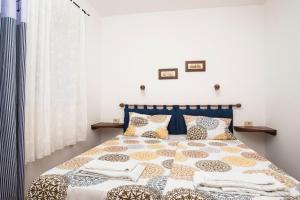 a bedroom with a bed with a blue headboard and pillows at House PUNTA UMAG in Umag