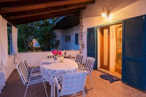 a table and chairs on a porch with a table and flowers at House PUNTA UMAG in Umag