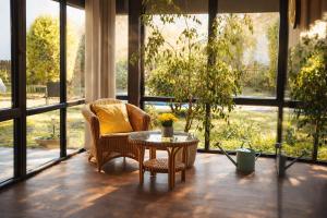a room with a chair and a table and windows at Villa Nirvána in Františkovy Lázně