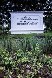 a sign for a park with some tall grass at Plern Pitch Residence in Pak Chong