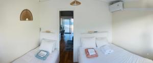 two beds in a room with two cell phones on them at Ilhéu à Vista in Água de Alto +22 photos