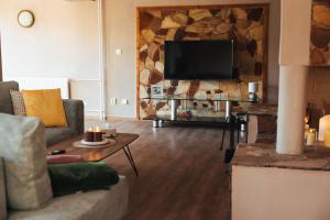 a living room with a couch and a tv at Villa Nirvána in Františkovy Lázně