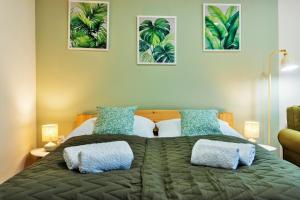 a bedroom with a large bed with blue and white pillows at BOTANIKA apartmanok Zsálya és Rozmaring in Baja