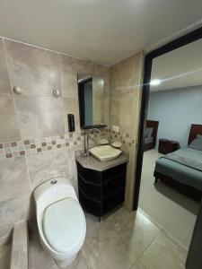 a bathroom with a toilet and a sink and a bed at Hostelfc Marly in Bogotá +79 photos