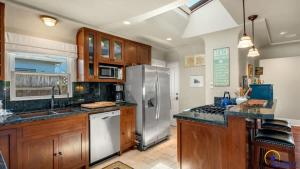 a kitchen with wooden cabinets and a stainless steel refrigerator at Ohana in Santa Cruz