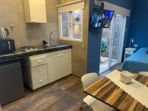a kitchen with a sink and a table with a tv at Aqui es 7 !! in Banfield +13 photos
