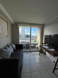 a living room with a couch and a large window at Departamento 610 in Temuco