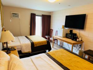 a hotel room with two beds and a flat screen tv at Armstrong Inn in Armstrong