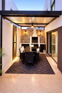 a dining room with a table and chairs on a rug at Modern Villa near Lisbon & Beaches with Heated Pool in Fernao Ferro