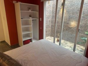 a bedroom with a bed and a large window at Aqui es 8!! in Banfield