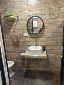 a bathroom with a sink and a mirror and a toilet at Aqui es 8!! in Banfield