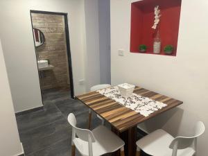 a dining room with a wooden table and white chairs at Aqui es 8!! in Banfield