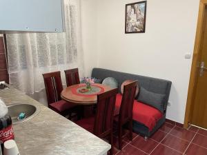 a kitchen with a small table with chairs and a counter at Apartman Ceca in Lepterija