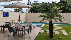 a table and chairs with an umbrella next to a pool at Paiva Ocean View - 17th Floor with Pool, Sauna & Jacuzzi in Recife