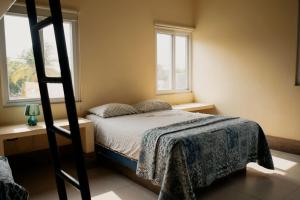 a bedroom with a bunk bed and two windows at Casa La Yola in Monterrico