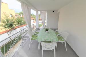 a balcony with a table and chairs on a balcony at House Casa Fabris with Pool in Umag