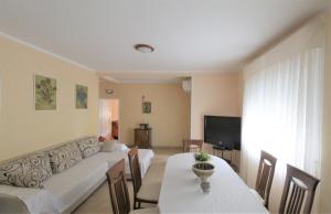 a living room with a couch and tables and a television at House Casa Fabris with Pool in Umag