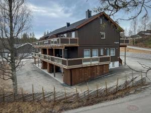 a large wooden house with a gambrel roof at Haugetuft Apartments in Åmot