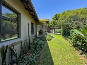 a house with a window and a grass yard at The Pearl Ballito in Ballito