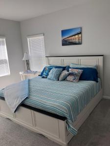 a bedroom with a large bed with blue pillows at Sunset Beach townhome close to everything in Ocean Isle Beach
