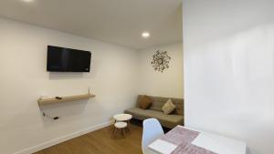 a living room with a couch and a tv on a wall at HDEZfalcon in Las Lagunas