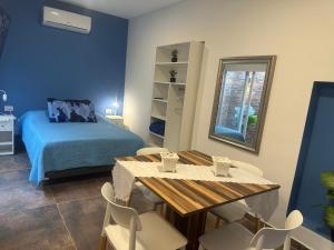a bedroom with a bed and a table and chairs at Aqui es 7 !! in Banfield