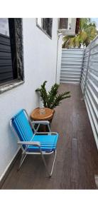 a blue chair and a table on a porch at CASA AMPLA e MODERNA com Suíte in Porto Velho