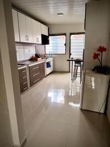 a kitchen with white cabinets and a table with a plant at CASA AMPLA e MODERNA com Suíte in Porto Velho