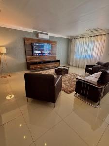 a living room with couches and a flat screen tv at CASA AMPLA e MODERNA com Suíte in Porto Velho