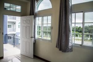 an open door in a room with windows at Plern Pitch Residence in Pak Chong