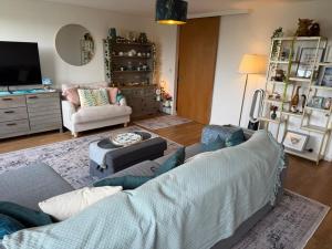 a living room with a couch and a tv at Thistle & Tide in Edinburgh