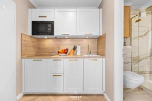 a kitchen with white cabinets and a sink at Ferienwohnung Margaritha List auf Sylt in List