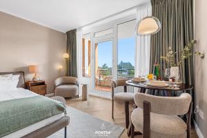 a hotel room with a bed and a table with a dining room at Ferienwohnung Margaritha List auf Sylt in List