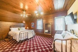 a bedroom with two beds in a room with wooden walls at Desperado - CA King Size Bed - Sleeps 2-4 in Lynchburg