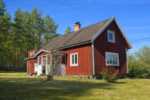 a red barn sitting on top of a grass field at Hus Idås in Fågelfors +24 photos