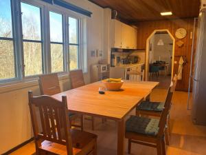a kitchen and dining room with a wooden table and chairs at Hus Idås in Fågelfors
