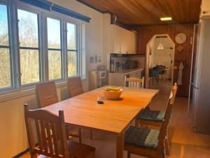 a kitchen and dining room with a wooden table and chairs at Hus Idås in Fågelfors