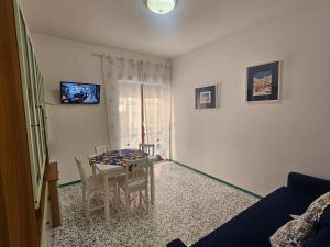 a living room with a table and chairs and a television at Daniela House in Maiori