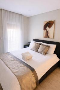 a bedroom with a large bed with white sheets at Modern Villa near Lisbon & Beaches with Heated Pool in Fernao Ferro +36 photos