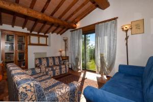 a living room with blue furniture and a large window at Casa Citille - Happy Rentals in Greve in Chianti