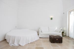 a white bedroom with a bed and a suitcase at Pane Amore e Magia in Anacapri