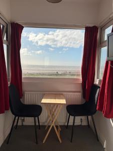 a room with a window with a table and two chairs at Cherish Lewis Sea View Hotel in Blackpool