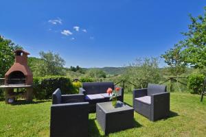 a backyard with two chairs and a table and a grill at Da Maria - Happy Rentals in Murlo +27 photos