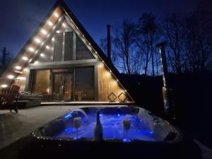 ein Whirlpool mit zwei Weingläsern und ein Haus in der Unterkunft AVA Chalet in Comarnic