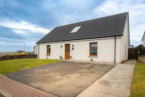 a white house with a black roof at 3 Breckan Brae in Orkney