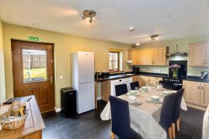 a kitchen with a table and a white refrigerator at 3 Breckan Brae in Orkney