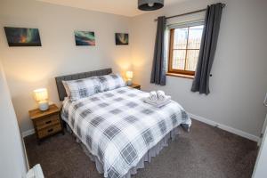 a bedroom with a bed with a checkered blanket at 3 Breckan Brae in Orkney