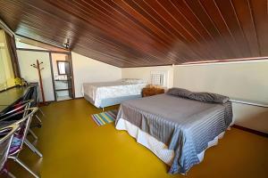 a bedroom with two beds and a wooden ceiling at Casa do Lord - Natú in Mata de Sao Joao +6 photos