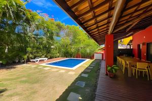 a backyard with a pool and a table and chairs at Casa do Lord - Natú in Mata de Sao Joao
