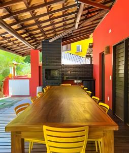 a conference room with a wooden table and yellow chairs at Casa do Lord - Natú in Mata de Sao Joao